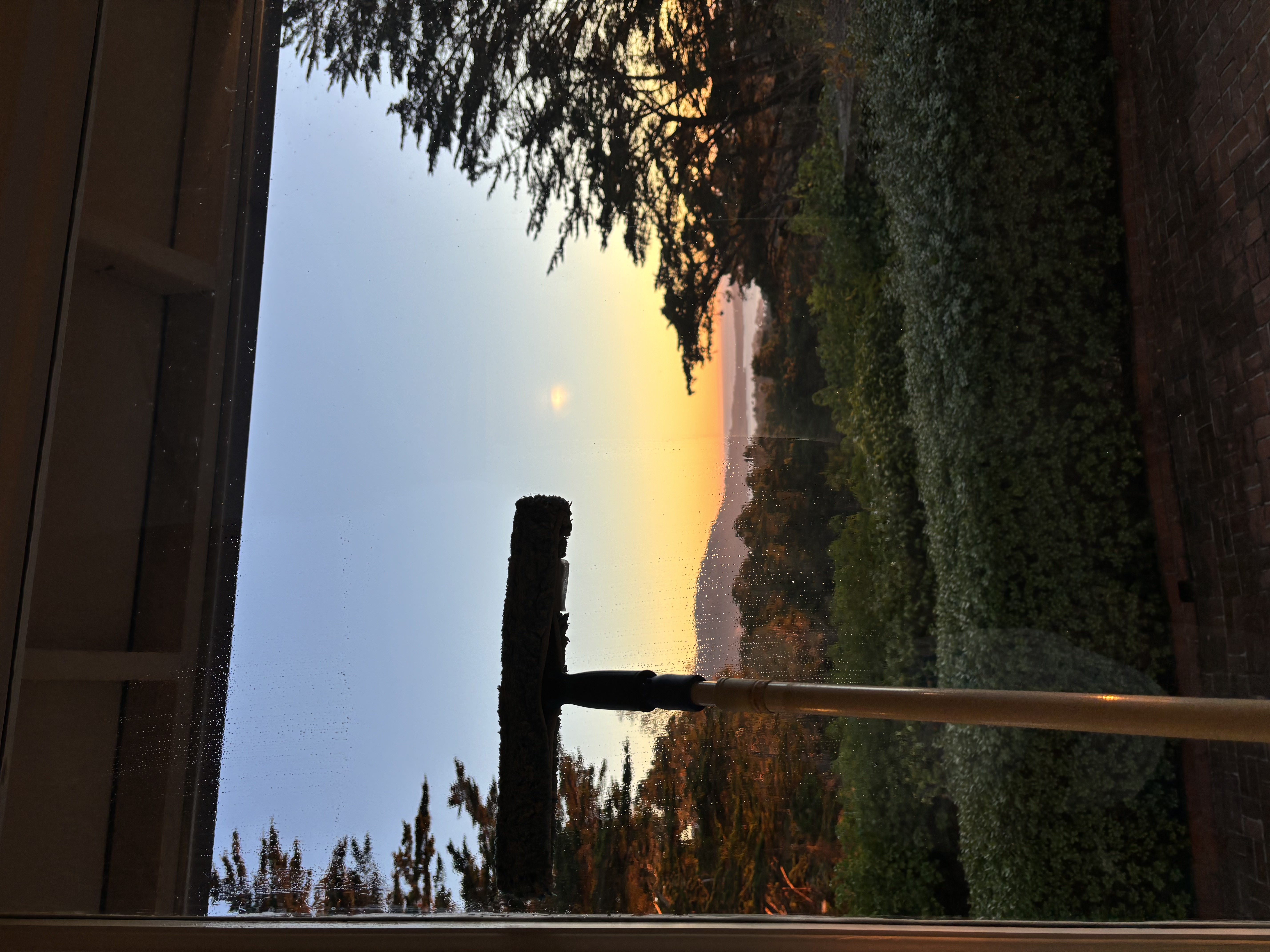 Professional window cleaning with squeegee at sunset on the Monterey coast